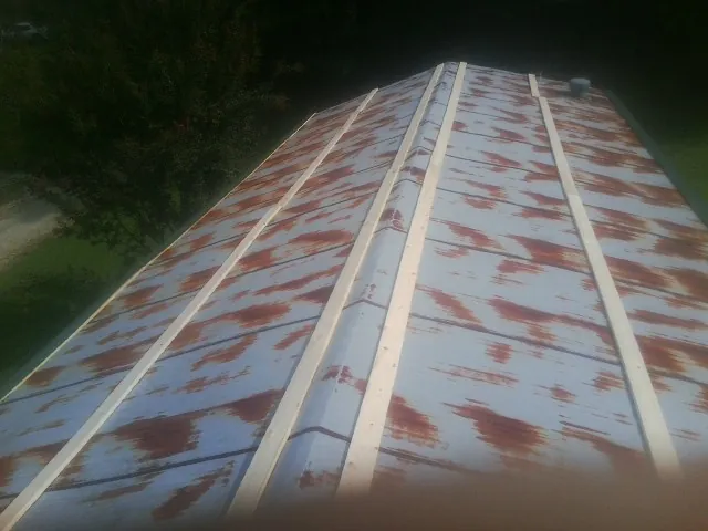 Rusted metal roof panels with new wood purlins before replacement — Storm Damage Roof Repair in Duson by Roofing Brothers